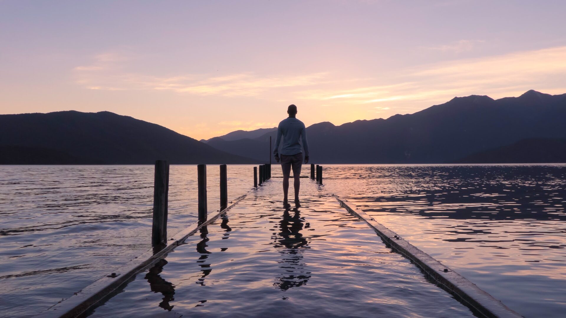 a man standing on a pier looking into the distance