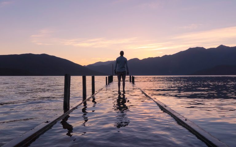 a man standing on a pier looking into the distance