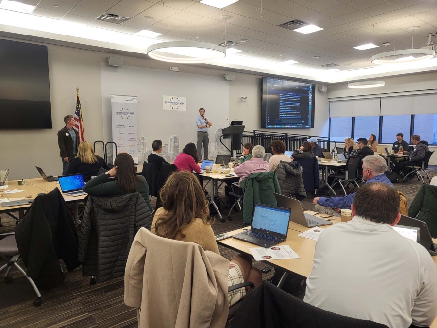 Dennis Cheatham and David Seidl present in front of a conference room of 40 people with laptops
